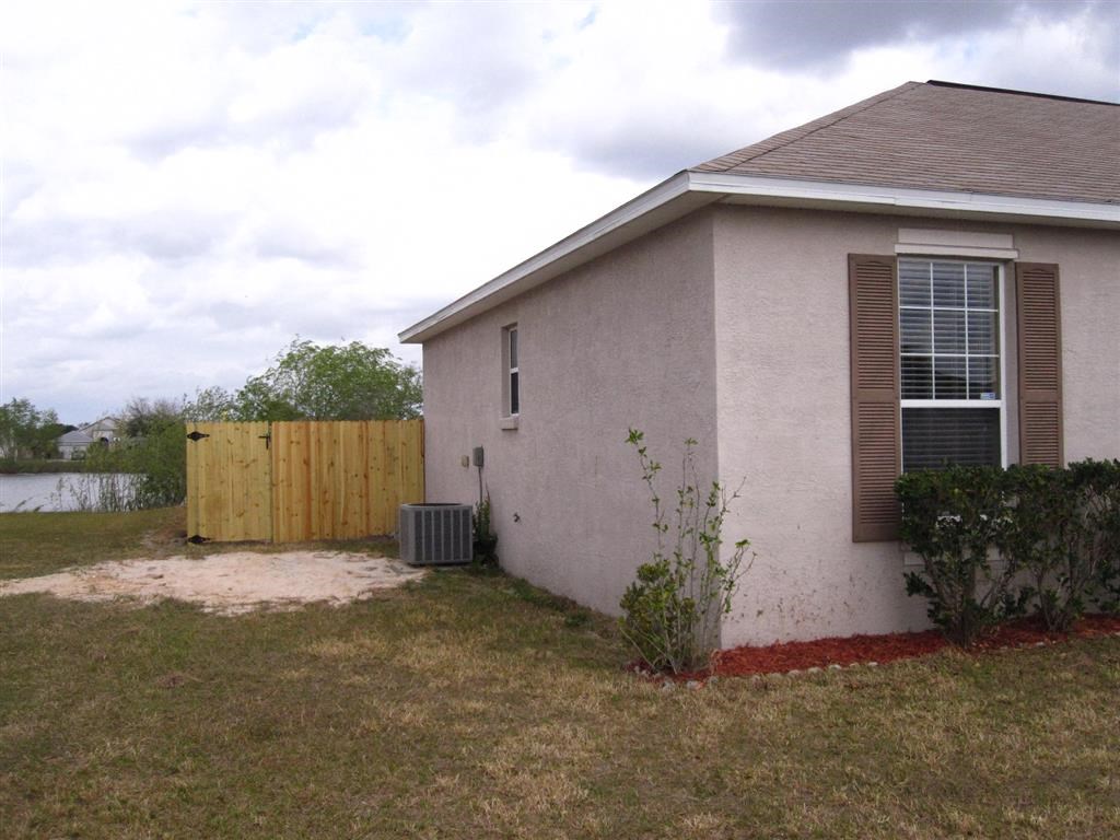 a white house with a fence and a body of water