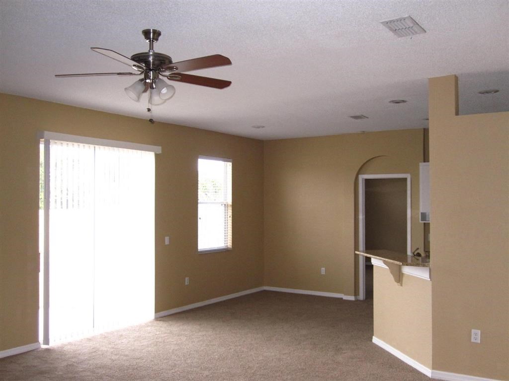 an empty living room with a ceiling fan