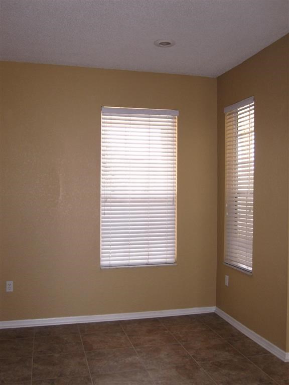 an empty room with a window and a tiled floor