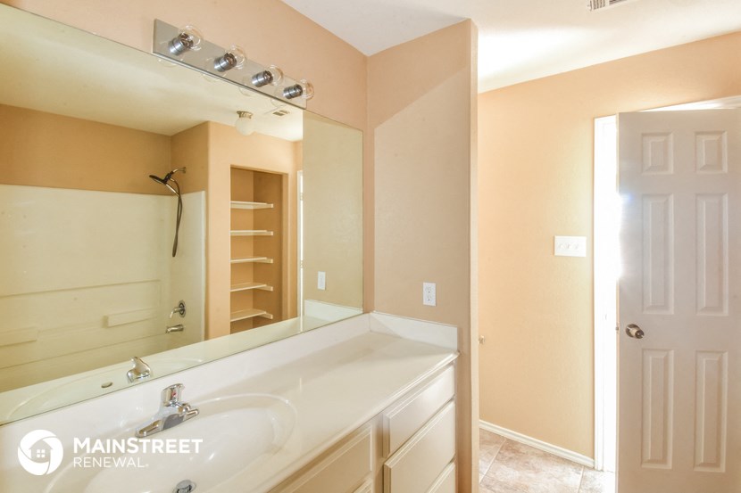 a bathroom with a large mirror and a white sink