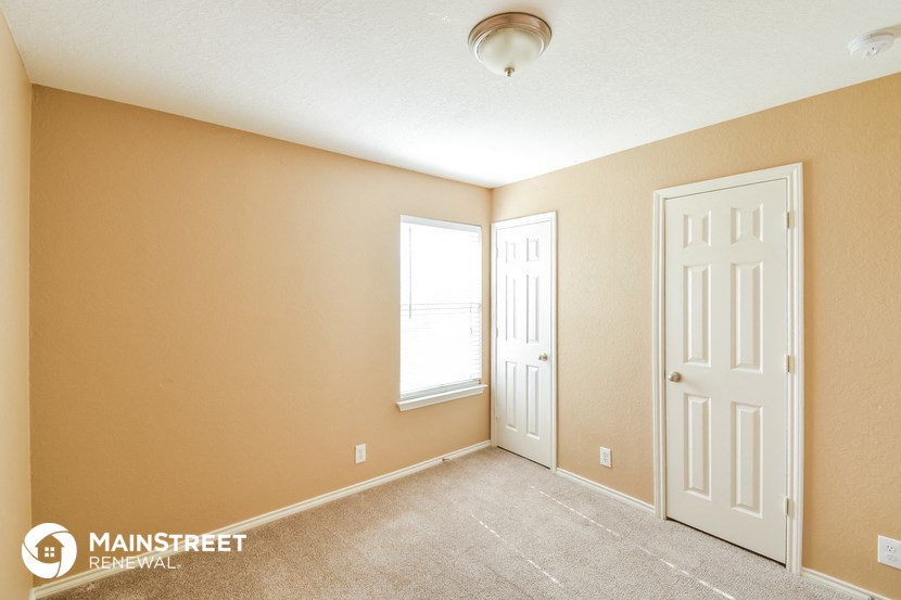the bedroom of this home has a carpeted floor and a white door