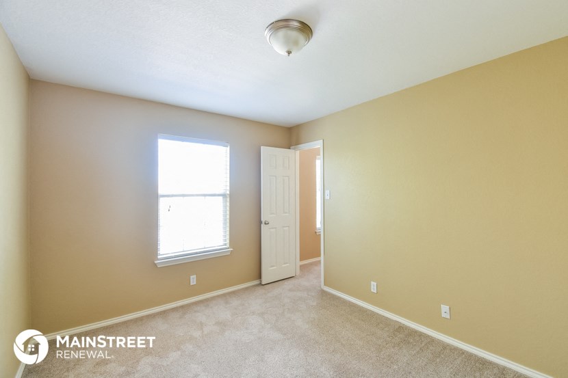 the upstairs bedroom with a door to the closet and a window