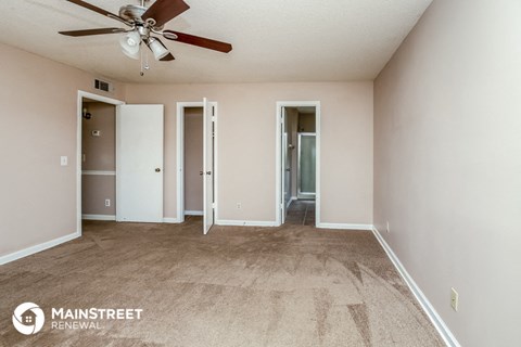 a living room with carpet and a ceiling fan