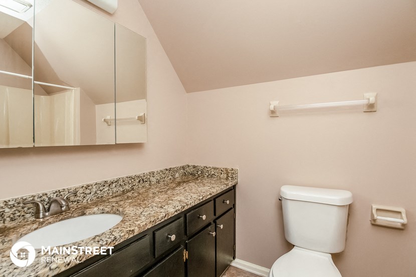 a bathroom with a granite counter top and a toilet