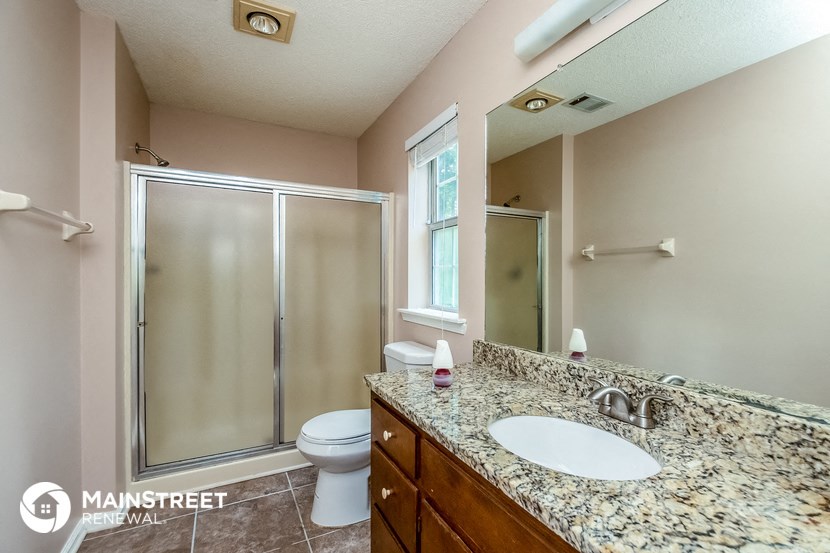 a bathroom with a sink and a shower and a toilet