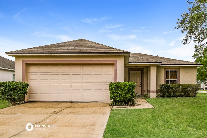 a house with a garage door and a lawn
