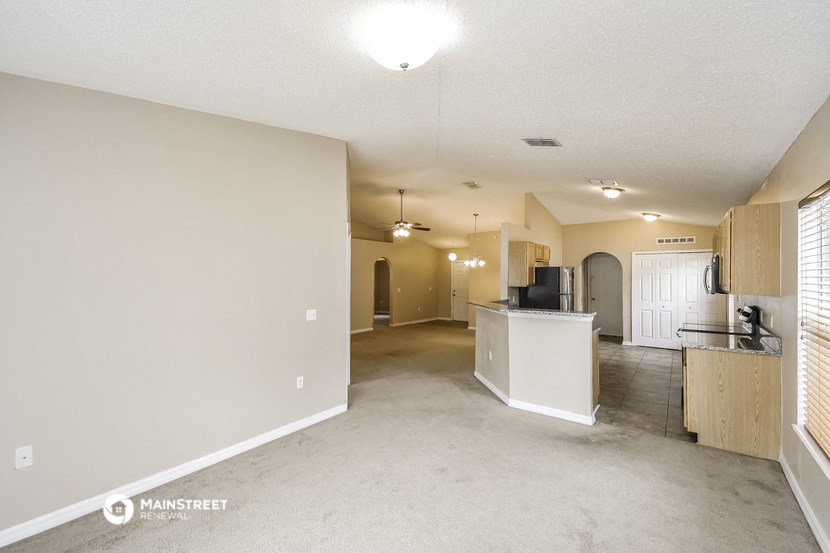 the living room and kitchen of an empty house