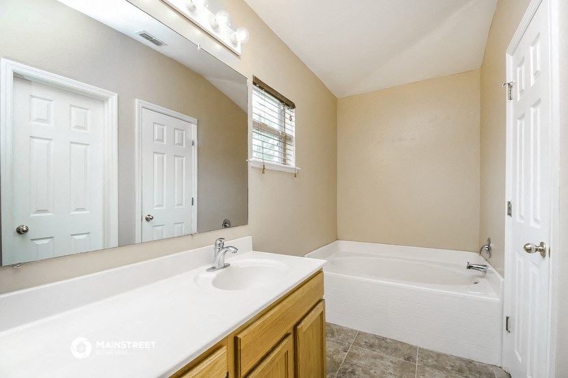 a bathroom with a sink and a tub and a mirror