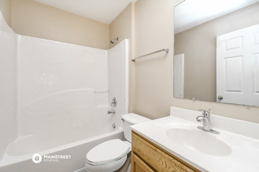 a bathroom with a sink toilet and tub and a mirror