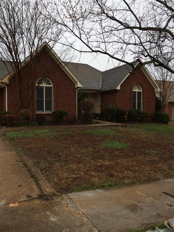 a brick house with a lawn in front of it