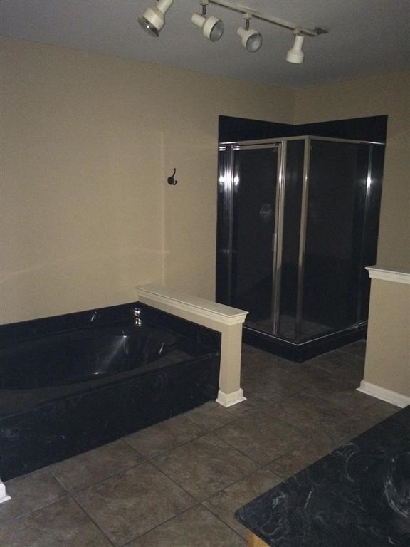 a bathroom with a black tub and a shower
