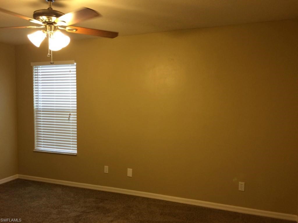 a empty room with a ceiling fan and a window