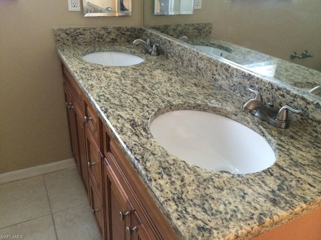a bathroom with two sinks and a granite counter top