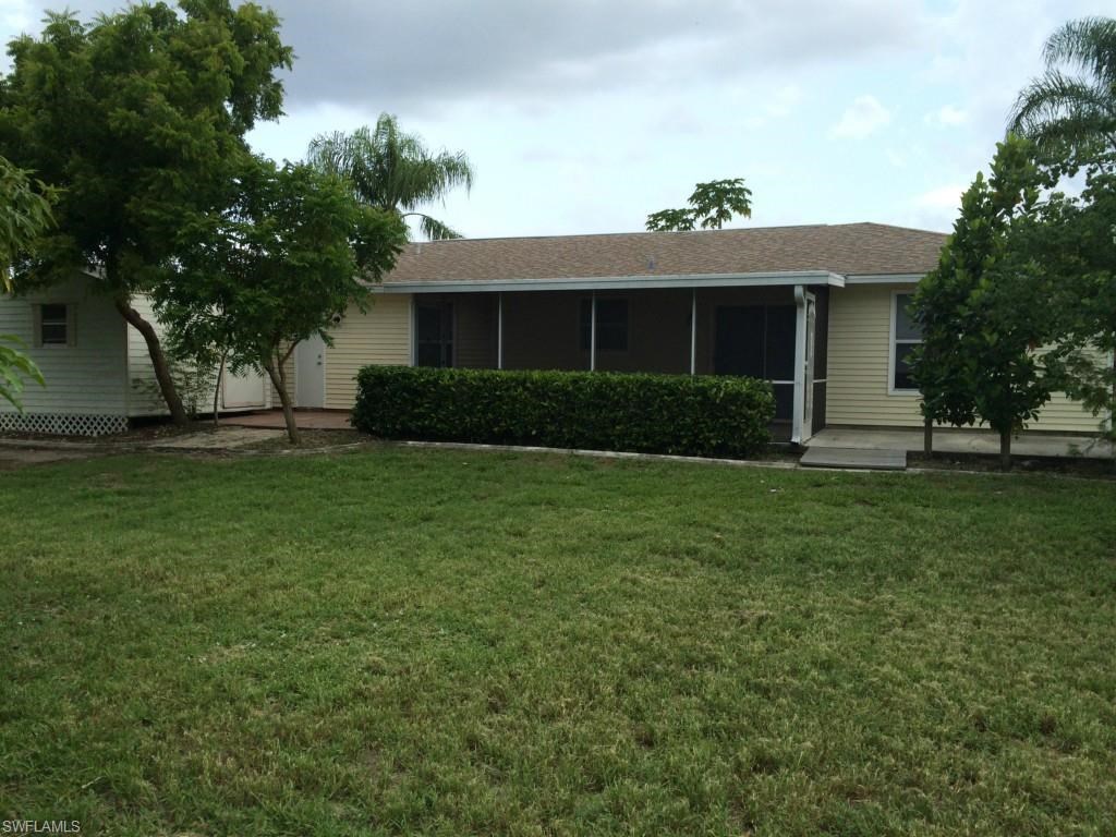 a home with a lawn and trees in front of it