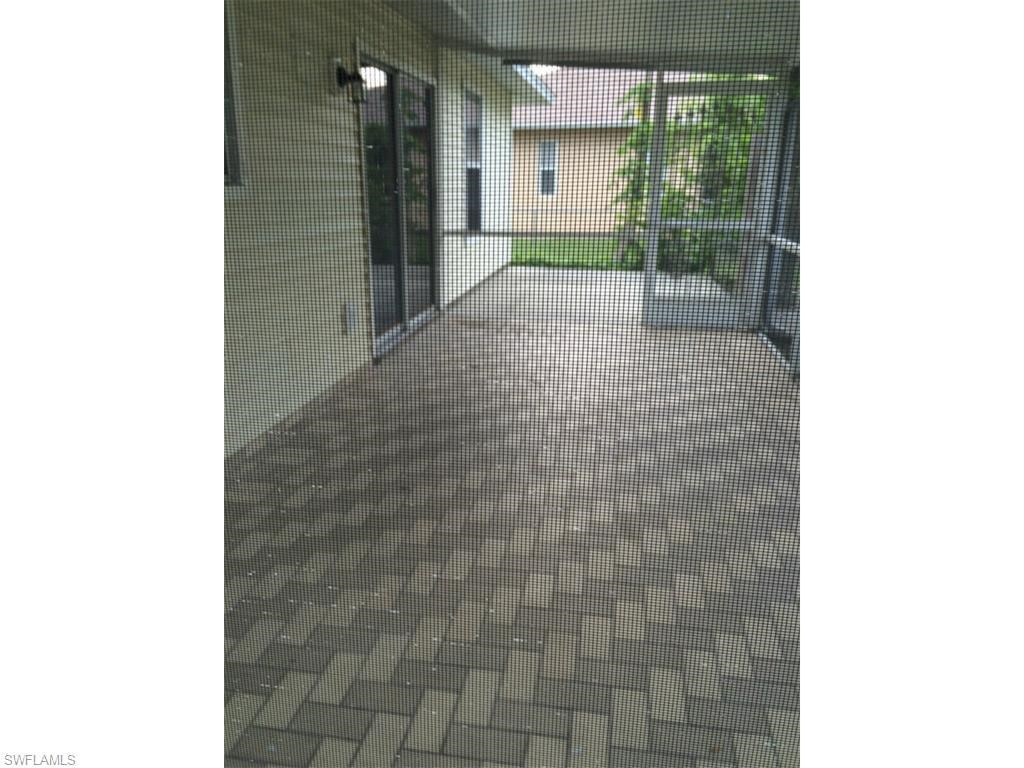 a hallway with a tiled floor and a glass door
