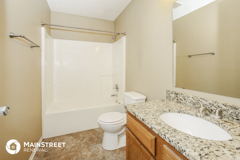 a bathroom with a shower toilet and sink and a mirror