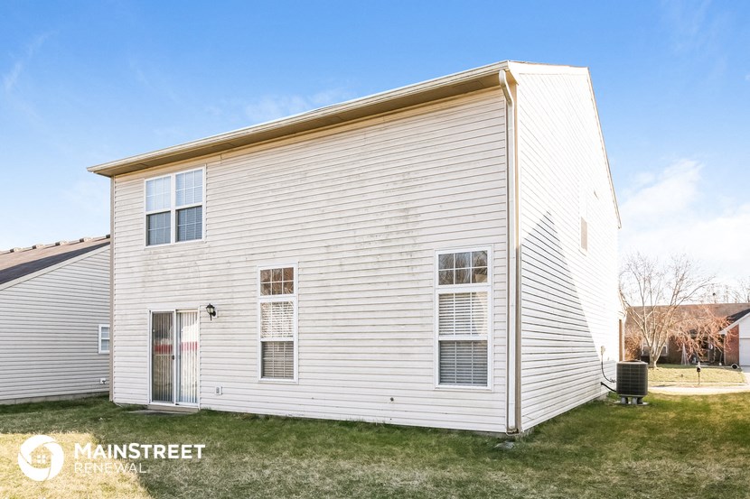 the outside of a white house with white siding and grass