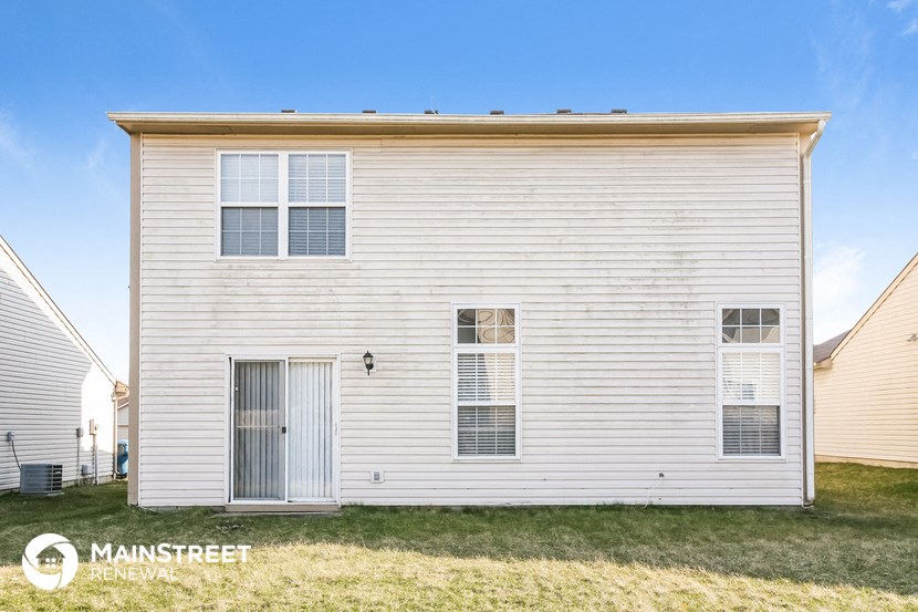 side view of a white house with white siding and grass