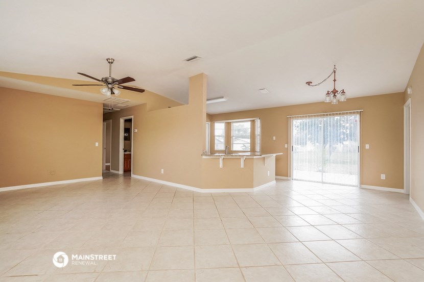 the living room and dining room are spacious with tile flooring and a ceiling fan