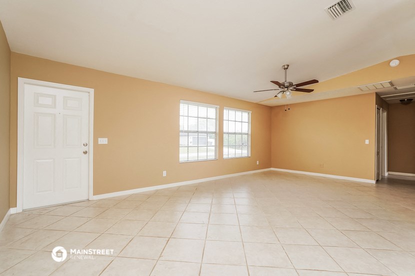 the living room of an empty house with a ceiling fan