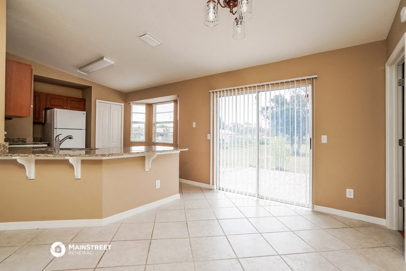 a large kitchen with a sliding glass door to the patio