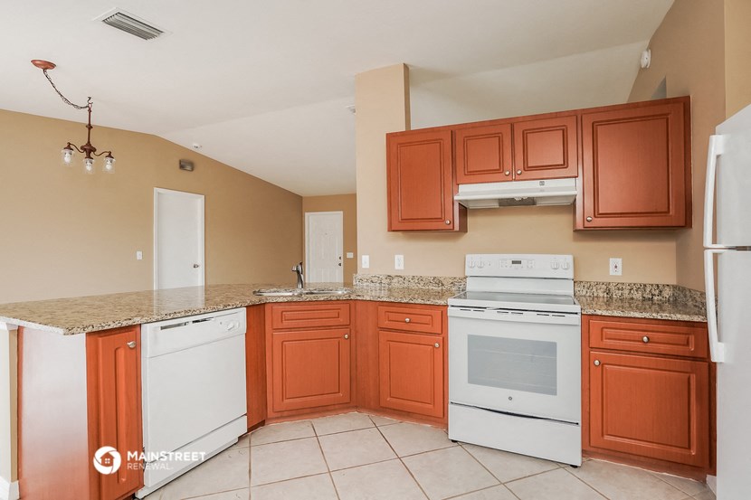 a kitchen with white appliances and wooden cabinets