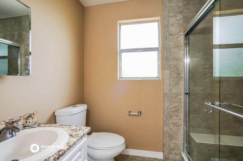 a bathroom with a toilet and a sink and a shower