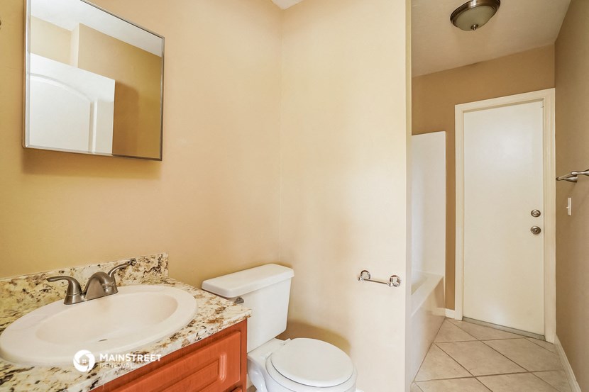 a bathroom with a sink and toilet and a mirror