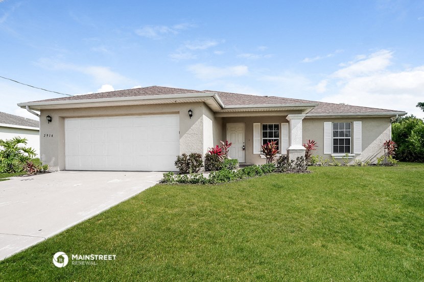 a white house with a lawn and a garage door