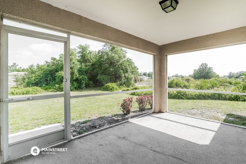 a living room with large windows and a view of the yard
