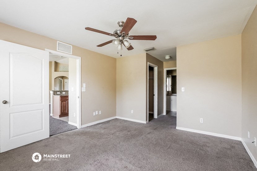 a living room with carpet and a ceiling fan