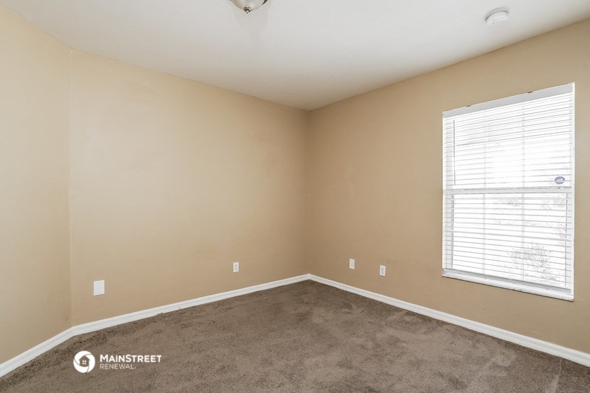 the living room of a home with carpet and a window