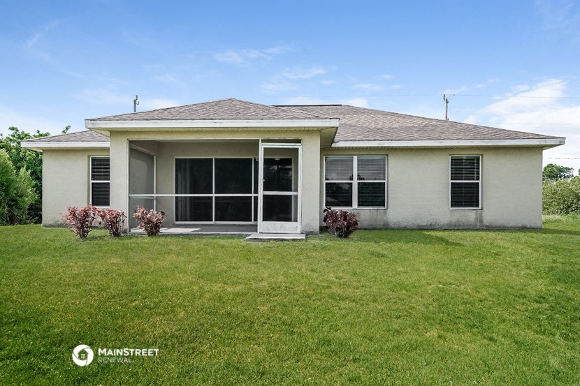 a small white house with a lawn in front of it