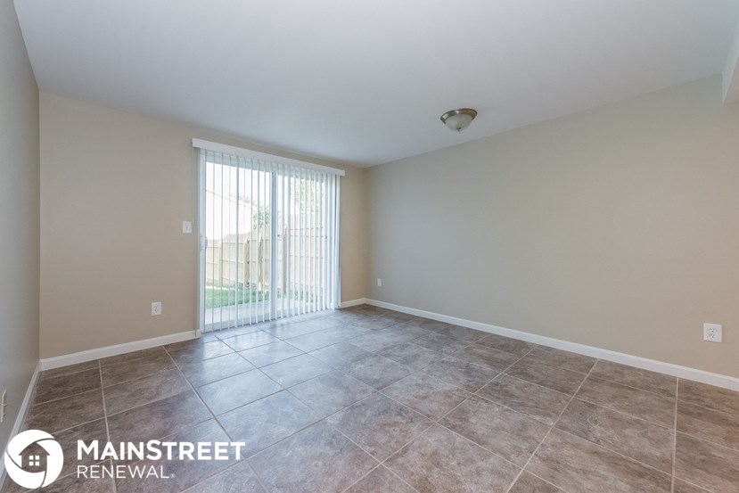 the spacious living room with sliding glass doors to the patio