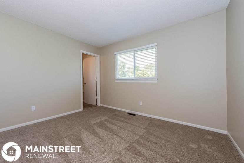 the living room of a home with carpet and a window