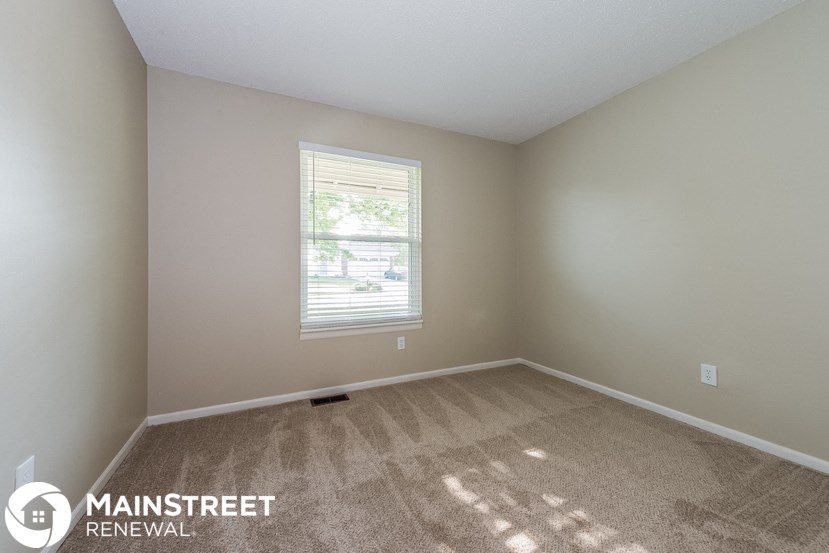 an empty room with carpet and a window