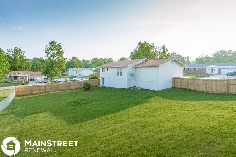 a backyard with green grass and a fence