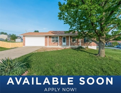 a house with a lawn and a tree in front of it