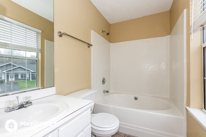a bathroom with a tub and a sink and a window