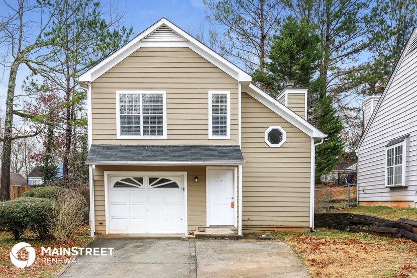 the front of a house with a garage and a white garage door