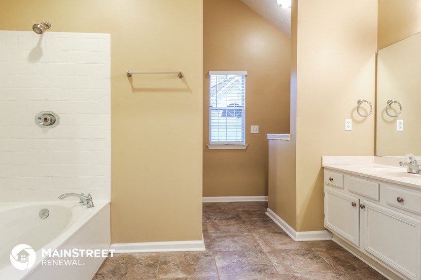 a bathroom with a tub and a shower and a sink