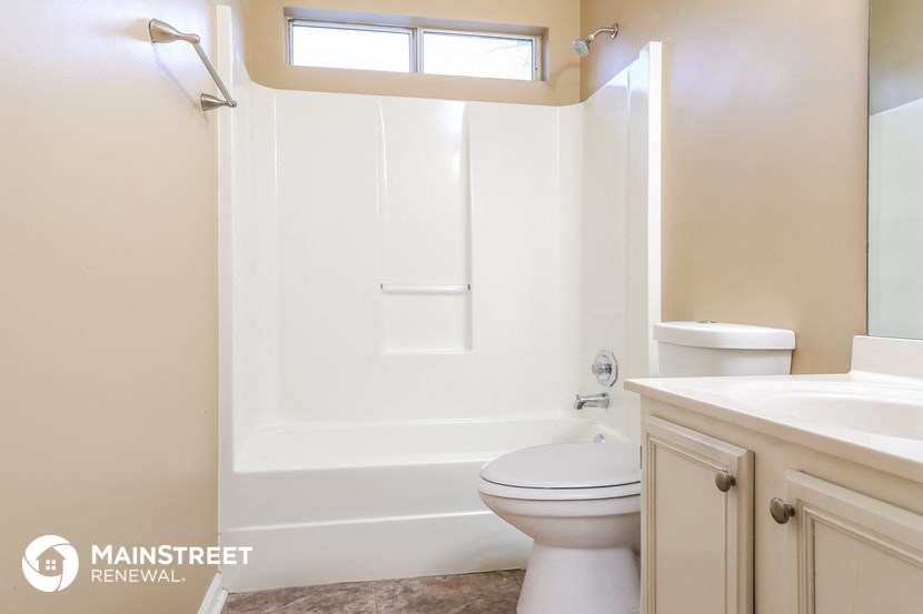 a bathroom with a toilet and a bath tub and a sink