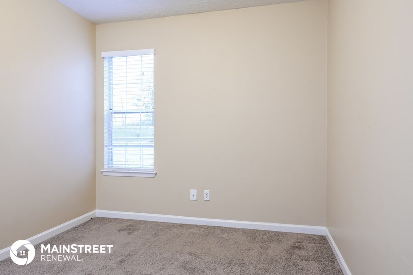 a room with a carpeted floor and a window