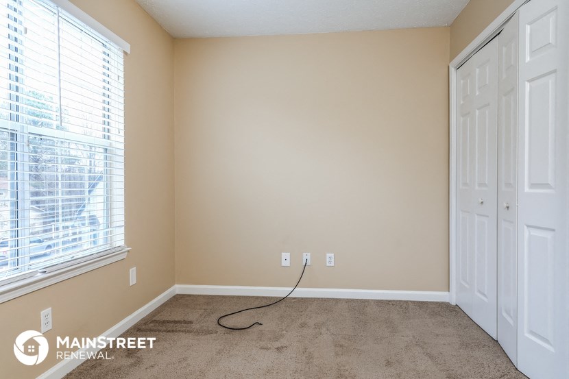the living room of a home with a carpeted floor and two white doors