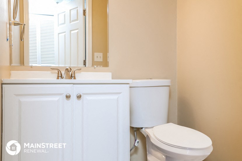 a bathroom with a toilet and a sink and a mirror