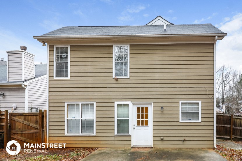 the front of a brown house with a white door
