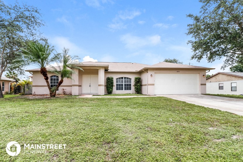 a home with a lawn and palm tree