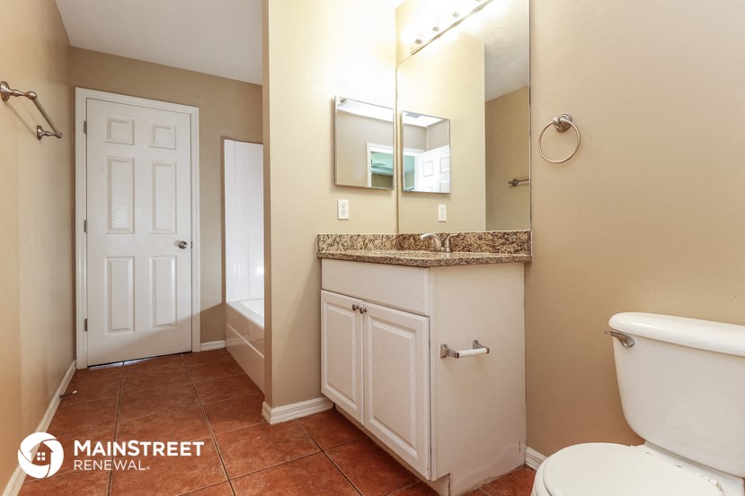 a bathroom with a toilet and a sink and a mirror