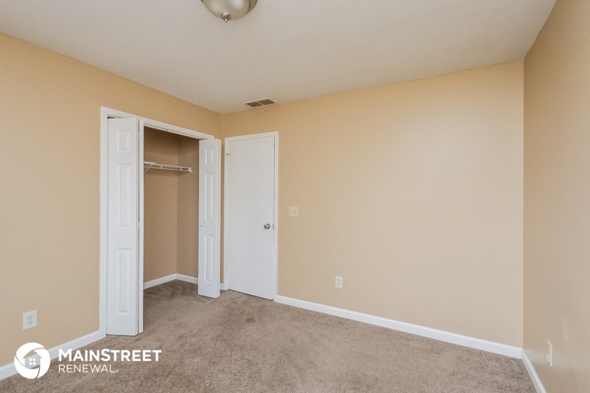 a room with a carpeted floor and a closet and an open door