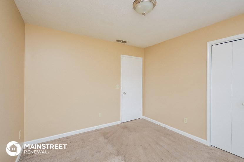 the spacious living room with a door to the bedroom
